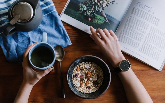 Person eating cereal reading a magazine