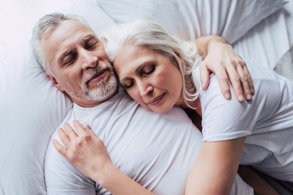 Older couple sleeping with husband suffering from sleep apnea